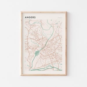 May include: Framed map print of Angers, France, in a minimalist style. The map features a network of brown roads and streets, with light blue rivers and lakes. The word "ANGERS" is printed at the top left.