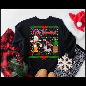 May include: Black Christmas sweater with a cartoon illustration of a man walking a donkey. The sweater has the text "Feliz Navidad" and snowflakes.