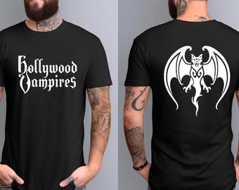 May include: A black short-sleeved t-shirt featuring the white text Hollywood Vampires on the front chest and a large white graphic of a winged bat-like creature on the back. The shirt has a crew neckline and a standard fit.