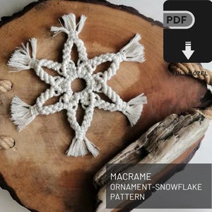May include: A white macrame snowflake ornament pattern, displayed on a wooden slice. The pattern is available as a PDF download.
