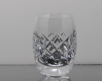 May include: A clear, cut-crystal tumbler with a diamond pattern. The glass has a rounded base and a straight, slightly flared rim. The intricate design catches the light, creating a sparkling effect. The tumbler is suitable for serving beverages.