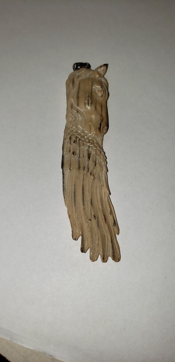 Hand-carved bone horse head with angel wings..