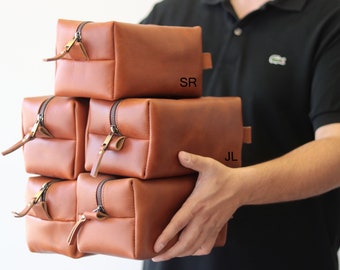 May include: Four brown leather zippered pouches with initials "SR" and "JL" on two of the pouches.