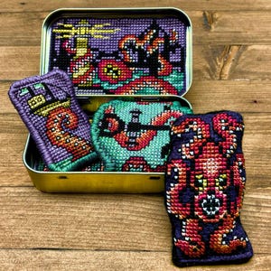 May include: A white ceramic mug with a black handle and the text "But First, Coffee" in a bold, black font. The mug is set against a blurred background, suggesting a cosy setting.