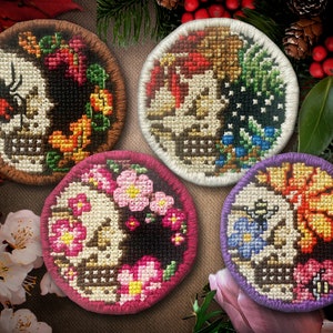 Puede incluir: Cuatro parches redondos bordados con un cráneo con diseños florales. Los parches son de color marrón, blanco, rosa y morado. Cada parche tiene un diseño floral diferente y un insecto diferente.