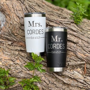 May include: Two stainless steel tumblers with black and white lids. The white tumbler has the text "Mrs. CORDES -Est 6.5.21" and the black tumbler has the text "Mr. CORDES -Est 6.5.21".