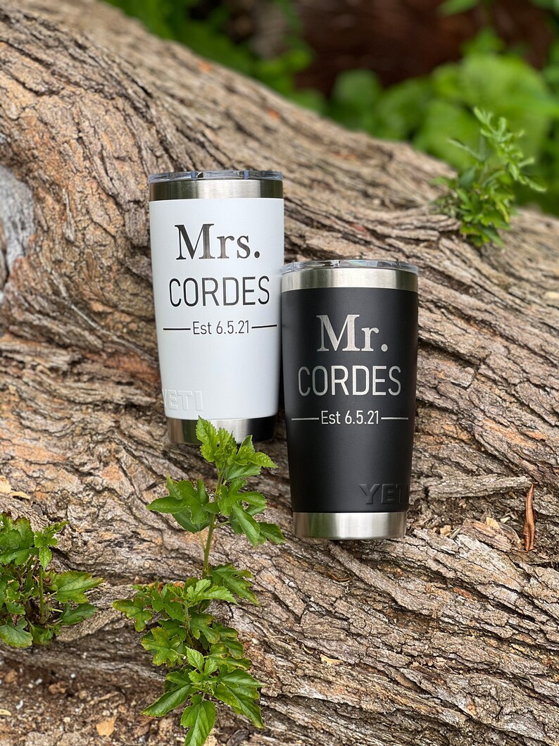 May include: Two stainless steel tumblers with black and white lids. The white tumbler has the text "Mrs. CORDES -Est 6.5.21" and the black tumbler has the text "Mr. CORDES -Est 6.5.21".