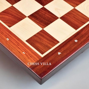 May include: Close-up of a wooden chessboard with a dark red and light wood finish. The board is labeled with letters and numbers along the edges. The text "Chess Villa" is printed on the board.