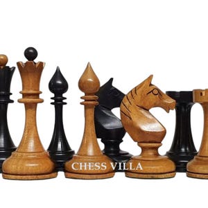 Op de afbeelding: Een verzameling houten schaakstukken in lichtbruin en zwart, waaronder koningen, koninginnen, lopers, paarden, torens en pionnen. De tekst CHESS VILLA is zichtbaar op de voet van een lichtbruin stuk. De stukken zijn in een rij opgesteld.