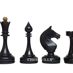 Op de afbeelding: Een set van zes zwarte houten schaakstukken, waaronder een koning met een licht houten knop, dame, loper, paard, toren en pion. De tekst CHESS VILLA is in het wit gedrukt op de voet van de loper en het paard tegen een effen achtergrond.