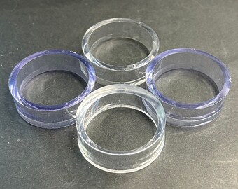 May include: Four clear plastic rings, stacked on top of each other. The rings are all the same size and shape, and they are made of a translucent material.