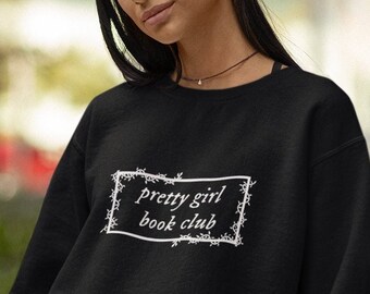 May include: Black sweatshirt with a white graphic that says "pretty girl book club" in a decorative frame.