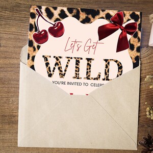 May include: An invitation card with a leopard print background and the words "Let's Get WILD" in bold letters. The card features a red bow and cherries, and is partially inside a kraft paper envelope.