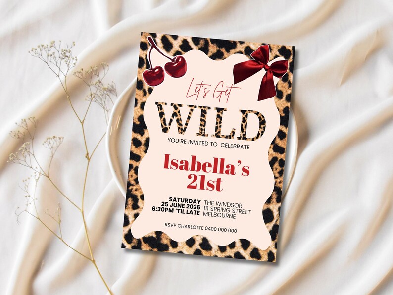 May include: A party invitation with a leopard print border and the words "Let's Get WILD" in a bold font. The invitation is for Isabella's 21st birthday, with event details including the date, time, and location. Decorative cherries and a bow are at the top.