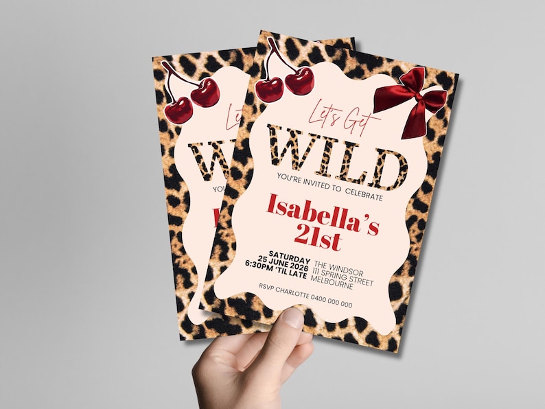 May include: Two party invitations with a leopard print border and a light pink center. The invitations read "Let's Get WILD" and "Isabella's 21st". Red cherries and a red bow are featured on the invitations.