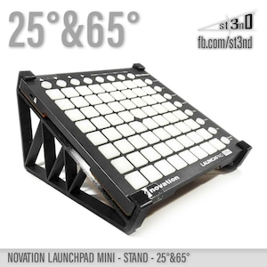 May include: Black stand for a Novation Launchpad Mini, angled at 25 degrees and 65 degrees. The stand is made of black plastic and has a triangular shape. The stand is designed to elevate the Launchpad Mini for better visibility and ergonomics. The stand is labeled "st 3nD" and "fb.com/st3nd".