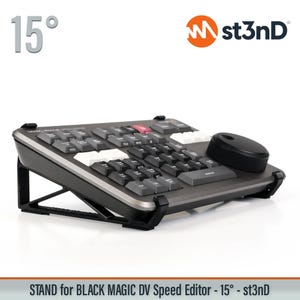 May include: A black and gray stand for a Black Magic DV Speed Editor, angled at 15 degrees. The stand features a keyboard with various buttons and a dial. The st3nD logo is visible in the upper right corner. The text "STAND for BLACK MAGIC DV Speed Editor - 15° - st3nD" is at the bottom.