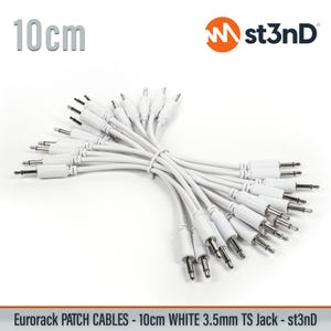 May include: A bundle of white 10 cm Eurorack patch cables with 3.5mm TS jacks. The cables are neatly tied together. The st3nD logo is visible in the upper right corner. The text "Eurorack PATCH CABLES - 10cm WHITE 3.5mm TS Jack - st3nD" is at the bottom.