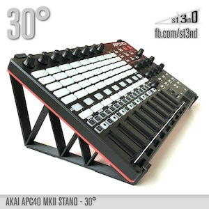Op de afbeelding: Zwarte standaard met rode accenten voor een Akai APC40 MKII MIDI-controller. De standaard is gekanteld met 30 graden. De tekst "st3nD fb.com/st3nd" is zichtbaar in de rechterbovenhoek van de afbeelding.