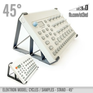 May include: A white Elektron Cycles or Samples synthesizer on a black stand angled at 45 degrees. The stand is made of plastic and has a triangular shape. The synthesizer has a black and white display and a variety of buttons and knobs.