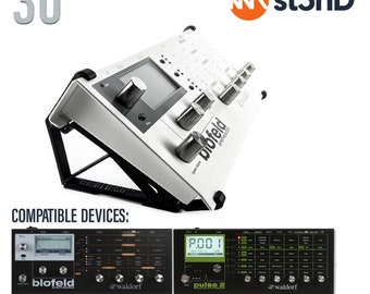 May include: A white stand for a Waldorf Blofeld or Pulse 2 synthesizer. The stand is angled at 30 degrees and has a black base. The stand is compatible with the Waldorf Blofeld and Pulse 2 synthesizers. The stand is labeled "st3nD".