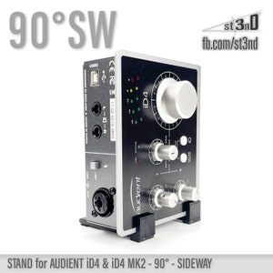 May include: A black stand for an Audient iD4 or iD4 MK2 audio interface. The stand is designed to position the interface at a 90-degree angle, allowing for a sideway orientation. The stand is made of black plastic and has a simple design.