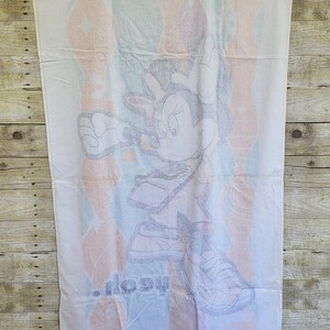 May include: White beach towel with a colorful design featuring a cartoon image of Mickey Mouse wearing a baseball cap and sneakers. The text "...ology" is printed on the towel.