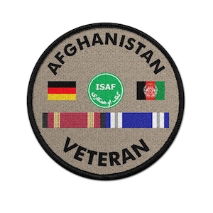 Puede incluir: Parche circular con la palabra "AFGHANISTAN" en la parte superior y "VETERAN" en la inferior. El parche presenta las banderas de Alemania y Afganistán, un emblema ISAF verde y cintas de servicio.