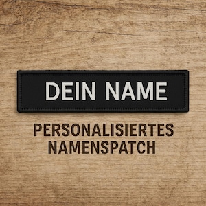 Puede incluir: Parche de nombre personalizado negro con texto blanco que dice "DEIN NAME" y las palabras "PERSONALISIERTE NAMENSPATCH" en texto marrón debajo del parche.