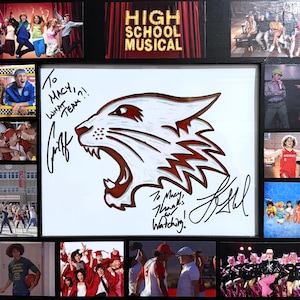 Può includere: Ricordi incorniciati di High School Musical. Il fulcro è un logo Wildcats bianco e rosso con firme e il testo "To Macy, What Team?!" e "To Macy, Thanks for Watching!" Immagini circostanti del film.