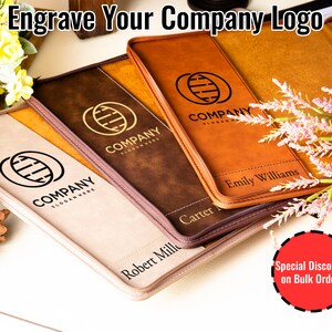 Op de afbeelding: Vier lederen mappen met een bedrijfslogo en gepersonaliseerde namen. De mappen zijn bruin, beige en lichtbeige. De tekst "Engrave Your Company Logo" staat bovenaan de afbeelding. Een rode cirkel met de tekst "Special Discounts on Bulk Orders" staat onderaan de afbeelding.