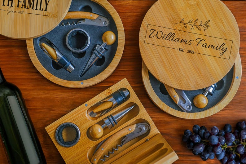 May include: Two round wooden boxes with lids, each containing a set of wine tools. The top box has the text "Williams Family Est. 2025" engraved on the lid. The bottom box has the text "Smith Family Since 1985" engraved on the lid. Both boxes have a black and white design.