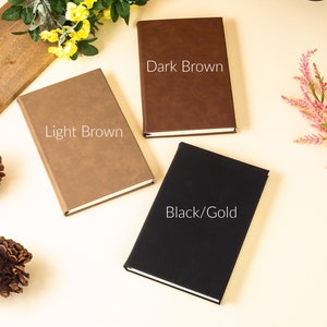 May include: Three closed notebooks with different colored covers: light brown, dark brown, and black with gold accents. The text on the covers reads "Light Brown", "Dark Brown", and "Black/Gold".