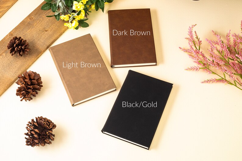 May include: Three closed notebooks with different colored covers: light brown, dark brown, and black with gold accents. The text on the covers reads "Light Brown", "Dark Brown", and "Black/Gold".