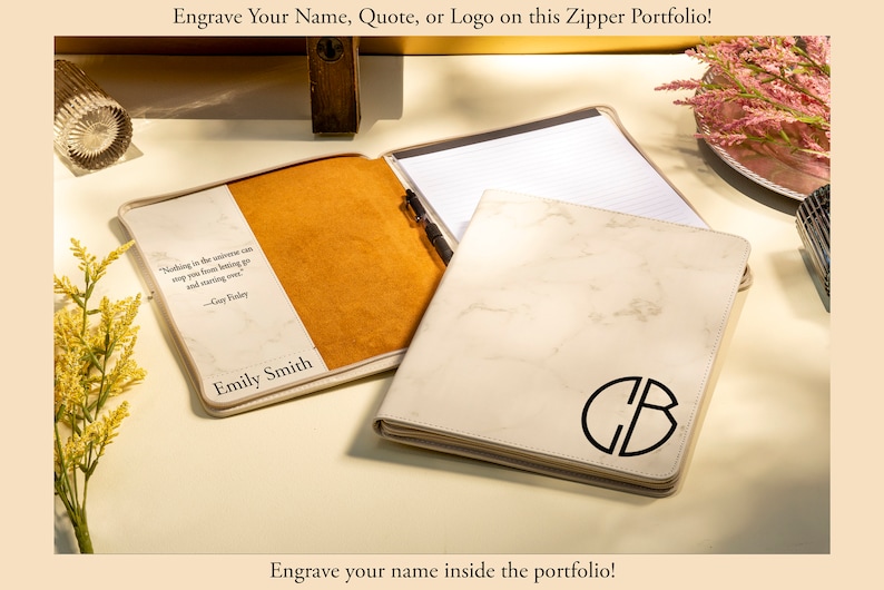 May include: Cream-colored zipper portfolio with a marble-like pattern and a black monogram. The open portfolio reveals a notepad and pen. The interior features a quote and name. Text on the image reads: "Engrave Your Name, Quote, or Logo on this Zipper Portfolio!" and "Engrave your name inside the portfolio!"