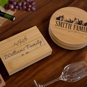 May include: Two personalised wooden chopping boards. One is rectangular with the text "Williams Family Est. 2025" and a small floral design. The other is round with the text "Smith Family Since 2025" and a mountain range design.