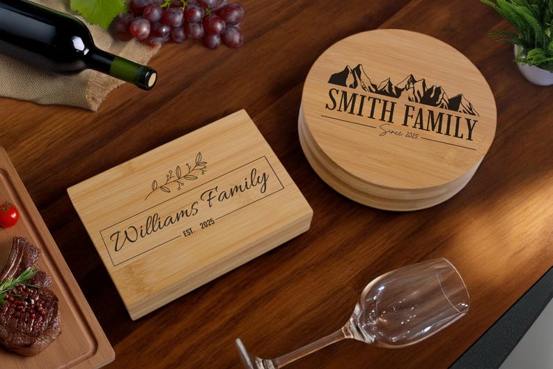 May include: Two personalised wooden chopping boards. One is rectangular with the text "Williams Family Est. 2025" and a small floral design. The other is round with the text "Smith Family Since 2025" and a mountain range design.