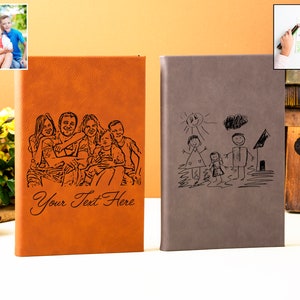 May include: Two brown leather journals with personalized engravings. One journal features a black and white photo of a family, the other features a black and white drawing of a family. The text "Your Text Here" is engraved on the journal with the photo.