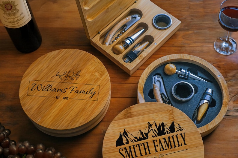 May include: Two personalised bamboo wine bottle opener sets. One set features a mountain design with the text "Smith Family Est. 2025". The other set features a floral design with the text "Williams Family Est. 2025".