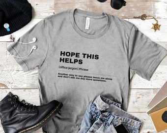 May include: Gray t-shirt with the text "HOPE THIS HELPS" in black, defined as "[office jargon] Phrase" and "Another way to say please leave me alone and don't ask me any more questions."