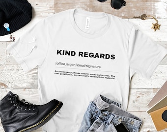 May include: White t-shirt with a black graphic design that defines "Kind Regards" as an unnecessary phrase used in email signatures. The text is "[office jargon] Email Signature. An unnecessary phrase used in email signatures. The real question is, are we really sending kind regards?"