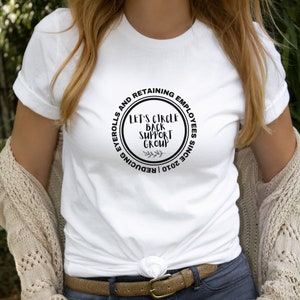 May include: White t-shirt with a black circle graphic that says "Reducing Eyerolls and Retaining Employees Since 2010 | Let's Circle Back Support Group".