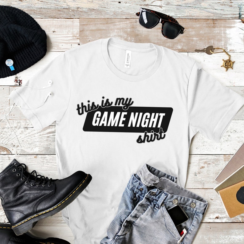 May include: White t-shirt with black text that says "This is my Game Night shirt".