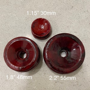 May include: Three wooden display stands in various sizes. The stands are a deep red color and have a glossy finish. The stands measure 1.15 inches, 1.8 inches, and 2.2 inches in diameter.