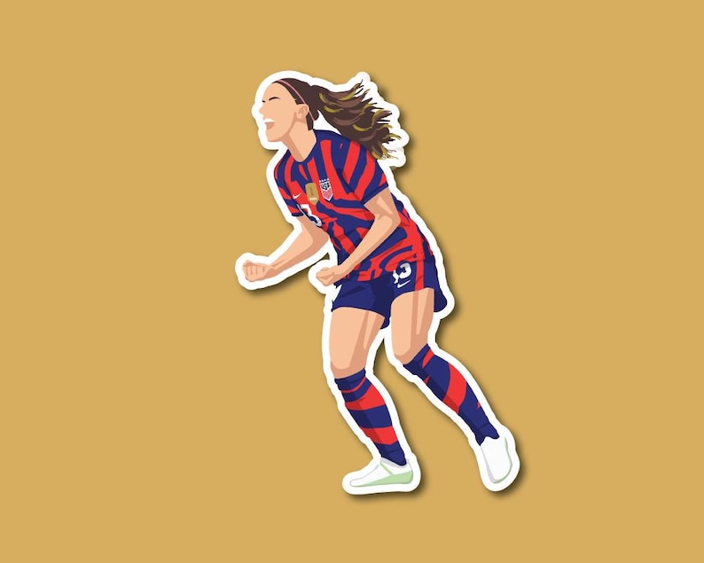 May include: A female soccer player wearing a red, white, and blue striped jersey with the number 13 on the back. She is celebrating a goal with her arms raised in the air.