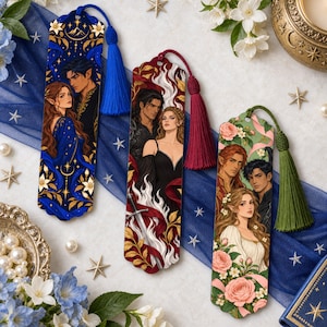 May include: Three rectangular bookmarks with scalloped edges and tassels. The first is blue with a couple and gold floral patterns. The second is red with a couple, flames, and a sword. The third is green with a couple and pink roses.
