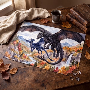 Peut inclure: Un puzzle rectangulaire représentant un grand dragon noir et un plus petit dragon bleu volant au-dessus d'un paysage avec une rivière, une cascade et des arbres d'automne. Le puzzle est partiellement assemblé sur une table en bois sombre.