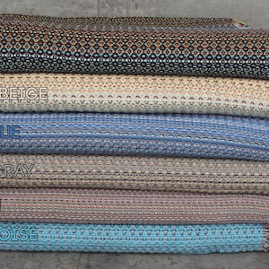 Pode incluir: Seis cores diferentes de tecido tecido com franjas. As cores são preto, bege claro, azul saxo, cinza escuro, marrom e turquesa.