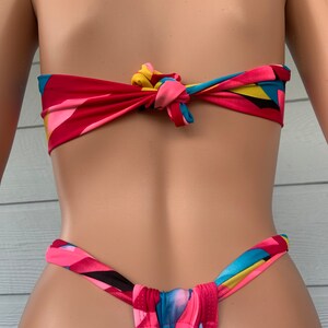 Pu&ograve; includere: Un top e un fondo bikini con stampa geometrica colorata e un design a nodo anteriore. La parte superiore &egrave; legata sul retro del collo e la parte inferiore &egrave; legata sui fianchi.