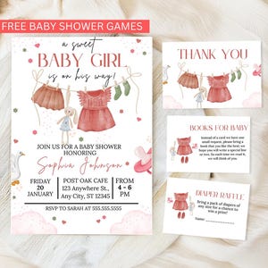 以下が含まれることがあります： ピンクと白のカラーテーマのベビーシャワー招待状。招待状には、洗濯ロープに掛けられたベビー服の水彩画が描かれています。招待状のテキストには、「a sweet baby girl is on his way!」「Sophia Johnson」と記載されています。